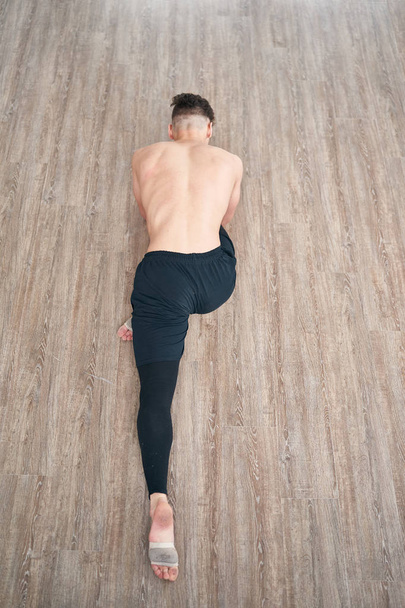 Handsome ballet dancer sitting on a splits - Valokuva, kuva