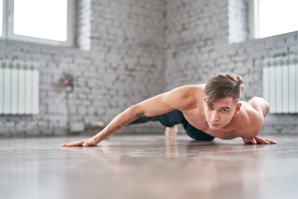 Athletic young man doing push ups on the floor - 写真・画像
