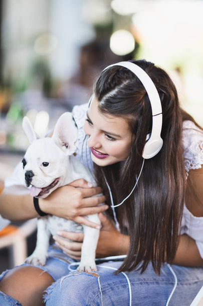 Beautiful young woman sitting in cafe with her adorable French bulldog puppy. Spring or summer city outdoors. People with dogs theme - Φωτογραφία, εικόνα