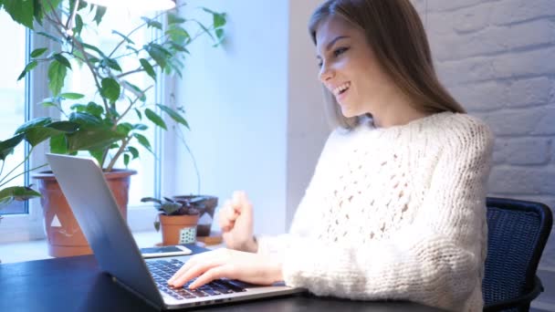 Chat de vídeo web en el ordenador portátil por la mujer joven, sentado en la oficina
 - Metraje, vídeo