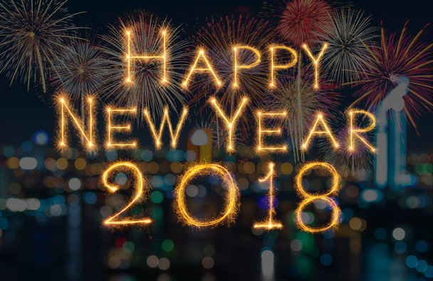 Szczęśliwego nowego roku 2018 napisane w blasku fajerwerków na fajerwerki z ciemnego tła, celebracja i kartki z życzeniami koncepcja - Zdjęcie, obraz