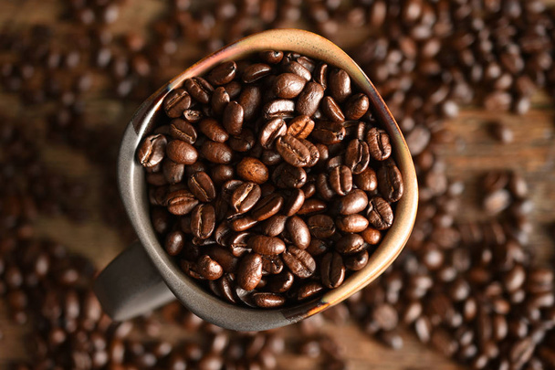A top view image of roasted coffee beans in a ceramic coffee cup.  - Foto, immagini
