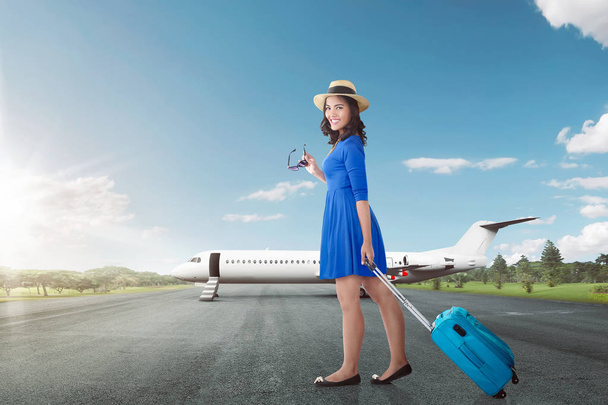 Attractive asian woman going vacation with airplane over blue sky background - Foto, afbeelding