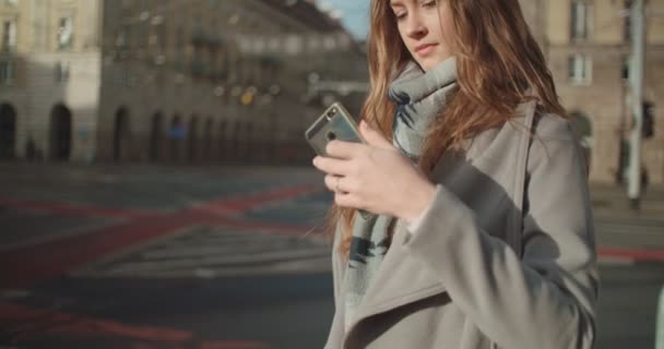 Attractive brunette young woman talking on phone while walking on a city street. - Filmagem, Vídeo