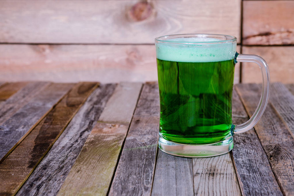 Одинокая кружка зеленого пива на деревянном фоне
 - Фото, изображение