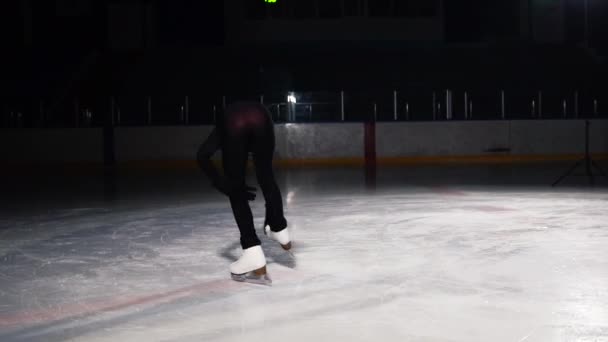 Buz üstünde bir kız patenci Close-Up buz pateni bir bacak üzerinde dururken kendi ekseni etrafında döndürme yürütmektedir. Kamera yavaş çekimde artistik patinajcı çevresinde yörüngede hareket eder - Video, Çekim