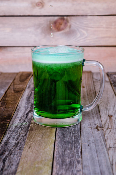 Single mug of green beer on wooden background - Photo, Image
