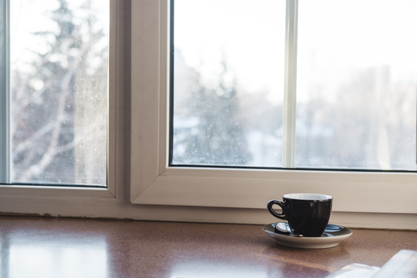 Puchar gorących napojów na stół z drewna, z białym oknie i światło słoneczne w godzinach porannych - Zdjęcie, obraz