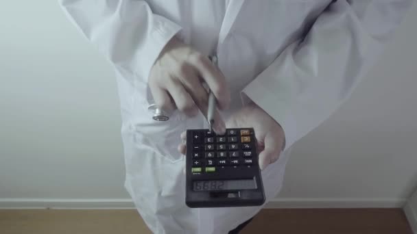 ヘルスケアの費用および費用の概念。スマート ドクターの手は、近代的な病院での医療費のため電卓を使用 - 映像、動画