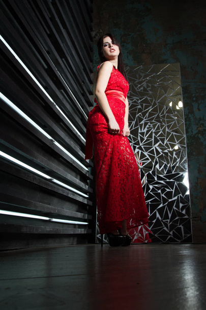 Egy hosszú piros ruhás lány. Stúdió-portré. - Fotó, kép