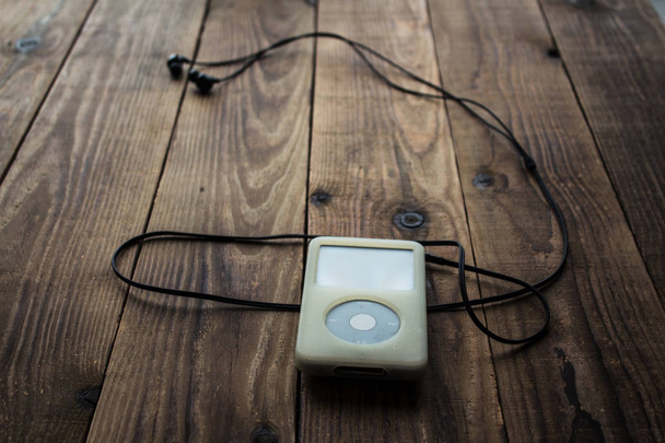 Odtwarzacz muzyki i słuchawki na podłoże drewniane - Zdjęcie, obraz