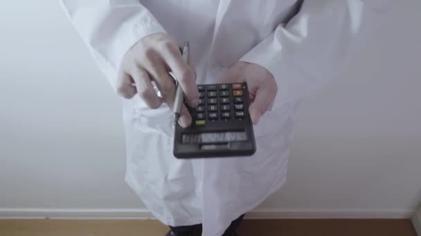 ヘルスケアの費用および費用の概念。スマート ドクターの手は、近代的な病院での医療費のため電卓を使用 - 映像、動画