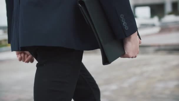 Man in black suit walks with a folder - Séquence, vidéo