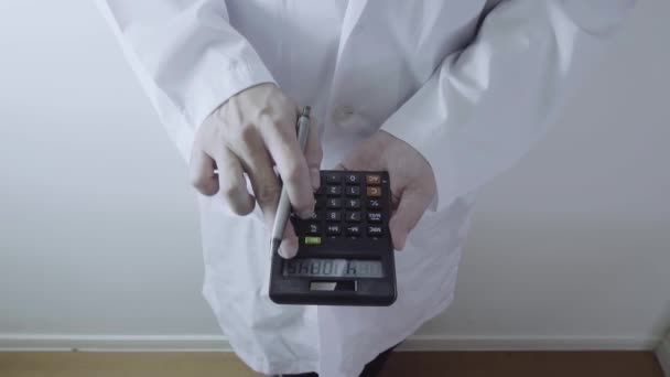Υγείας δαπάνες και αμοιβές έννοια. Χέρι του smart γιατρός χρησιμοποιείται μια αριθμομηχανή για ιατρικά έξοδα στο σύγχρονο νοσοκομείο - Πλάνα, βίντεο