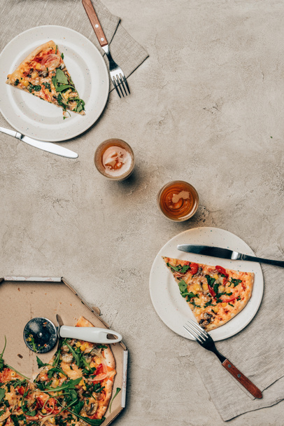 Dinner template with pizza slices on plates and drink glasses on light background - Valokuva, kuva