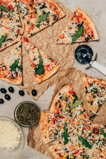 Slices of Italian pizza and cooking ingredients on light background - Foto, afbeelding
