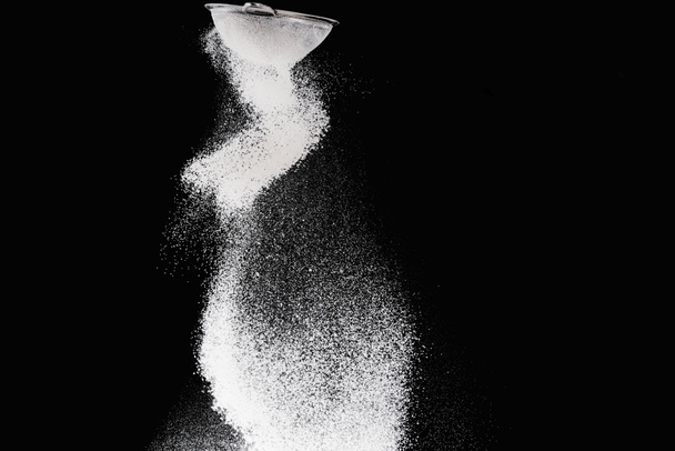 sieve with falling flour isolated on black - Foto, Imagem
