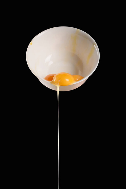 bowl with pouring out chicken eggs isolated on black - Fotografie, Obrázek