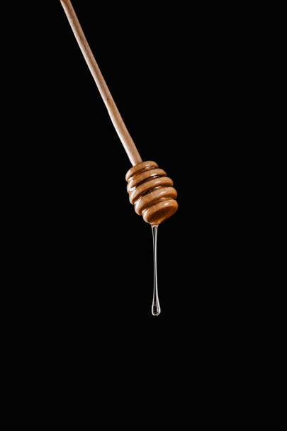 honey dripping from honey stick isolated on black - Photo, Image