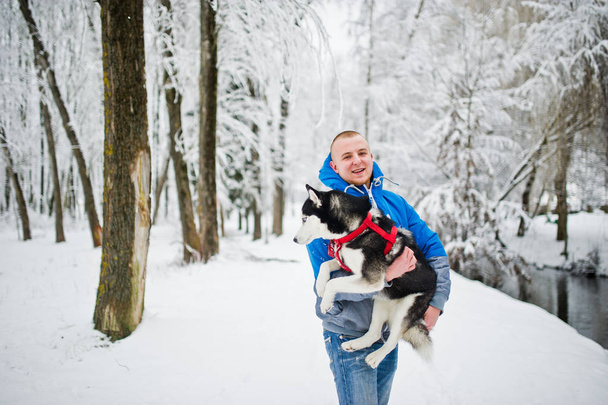 Man with husky dog at winter snowy park. - Fotografie, Obrázek