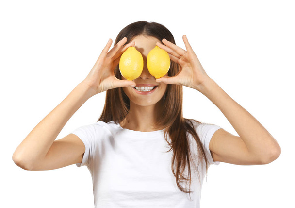 Beautiful young woman with ripe lemons on white background - Photo, image