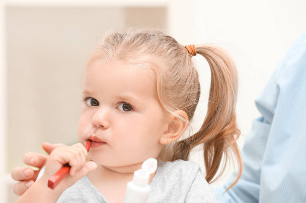 Little girl brushing teeth in bathroom - Foto, afbeelding
