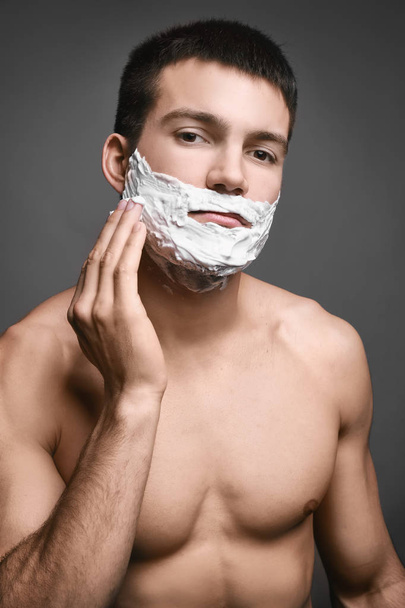 young man with shaving foam - Фото, зображення