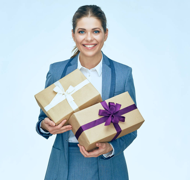 portrait of beautiful businesswoman in grey business suit holding gift boxes  - Zdjęcie, obraz
