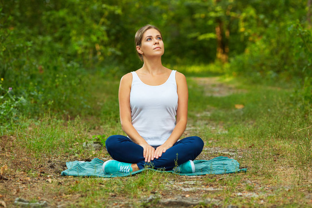 schöne Frau in Yoga-Pose meditiert im Wald  - Foto, Bild