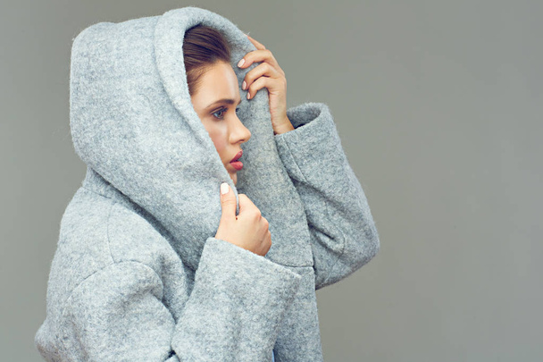 portrait of young beauty woman wearing gray coat with big hood  - Foto, Bild
