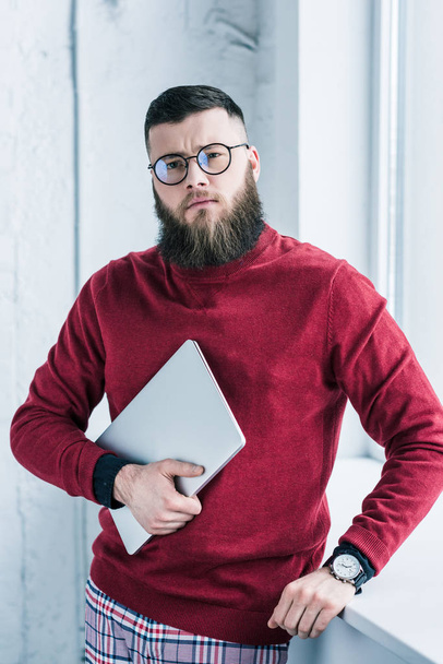 portrait of stylish businessman in eyeglasses holding laptop - Photo, Image