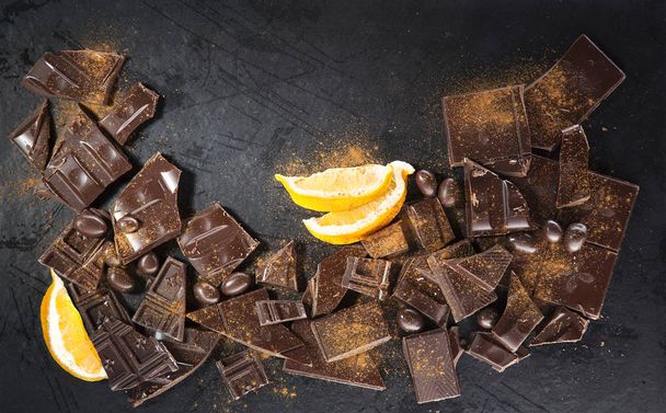 Chocolate rachado com fatias de limão no fundo preto
 - Foto, Imagem