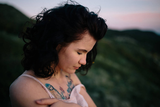 Retrato de mujer joven hermosa morena al aire libre en campo en crepúsculo. Chica guapa en la naturaleza - Foto, imagen
