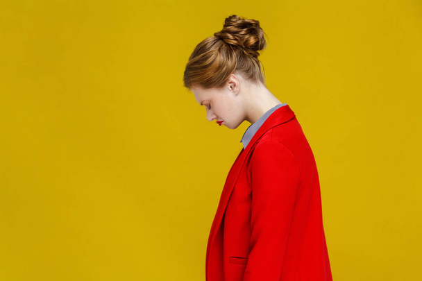side view of frustrated redhead businesswoman in red jacket on yellow background - Valokuva, kuva