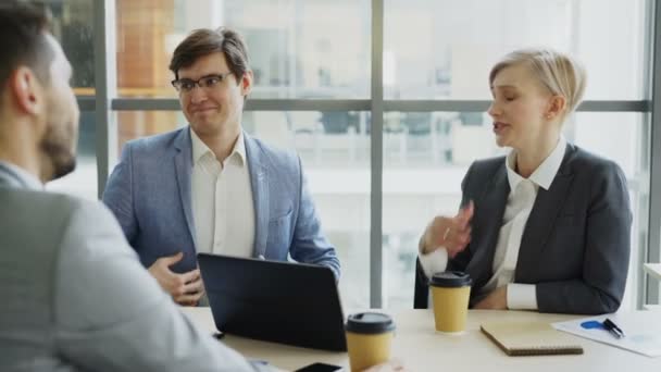 Business team chatting while sitting in modern office indoors during coffee break - Materiał filmowy, wideo