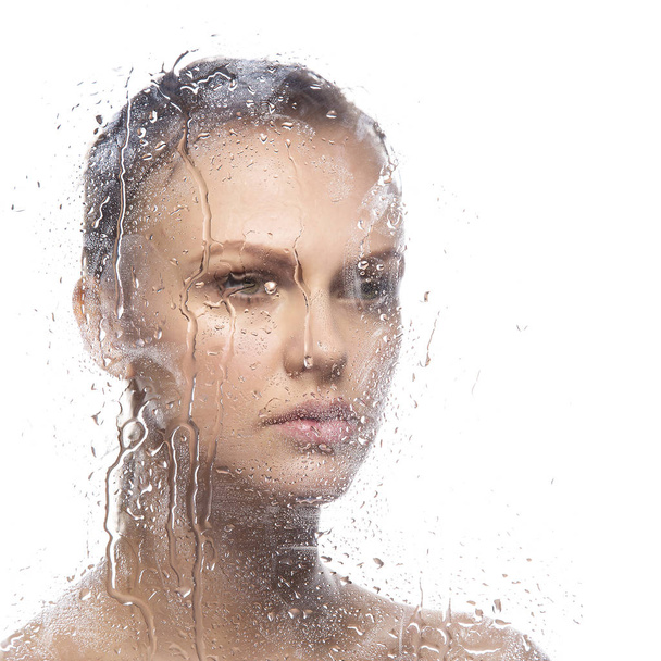 Πορτρέτο της νεαρής γυναίκας μέσα από υγρό γυαλί - Φωτογραφία, εικόνα