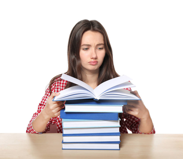 Cute teenager girl with lot of homework to do against white background - Φωτογραφία, εικόνα