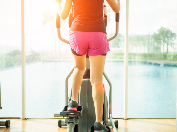 Fermez les jambes de la femme travaillant sur le vélo d'exercice dans la salle de fitness. concept d'exercice
. - Photo, image
