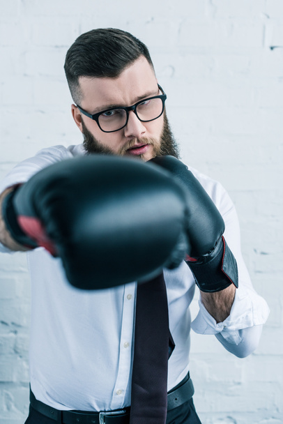 избирательный фокус концентрированного бизнесмена в боксёрских перчатках
 - Фото, изображение