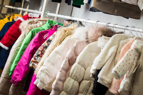 детская одежда висит на полке в дизайнерском магазине
 - Фото, изображение