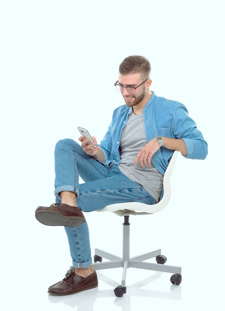 Young man sitting on chair and using mobile phone. Startupper. Young entrepreneur. - Foto, Imagem
