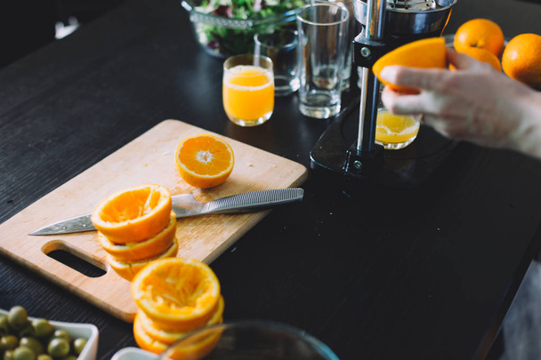 young woman squeezing orange juice at home  - Fotoğraf, Görsel