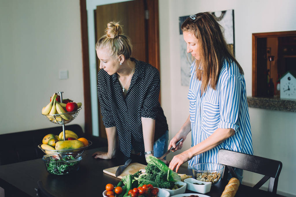緑の野菜サラダ、新鮮な野菜を切る 2 つの女性健康食品調理 - 写真・画像