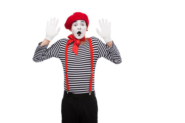 Schockierter Mime steht isoliert auf weißem Grund mit erhobenen Händen - Foto, Bild