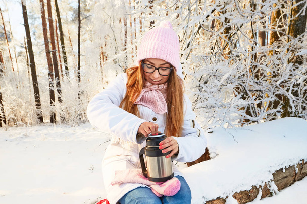 девушка в розовой шляпе с термосом зимой в лесу
. - Фото, изображение