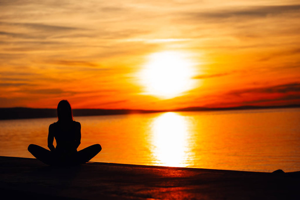 Unbekümmerte ruhige Frau, die in der Natur meditiert. inneren Frieden finden.Yoga praktiziert.spirituelle Heilung Lebensstil.Frieden genießen, Anti-Stress-Therapie, Achtsamkeitsmeditation.Positive Energie.Lotus-Pose - Foto, Bild