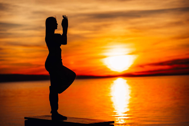 Carefree woman meditating in nature.Finding inner peace.Yoga practice.Spiritual healing lifestyle.Enjoying peace,anti-stress therapy,mindfulness meditation.Positive energy.Garudasana,eagle pose - Photo, Image