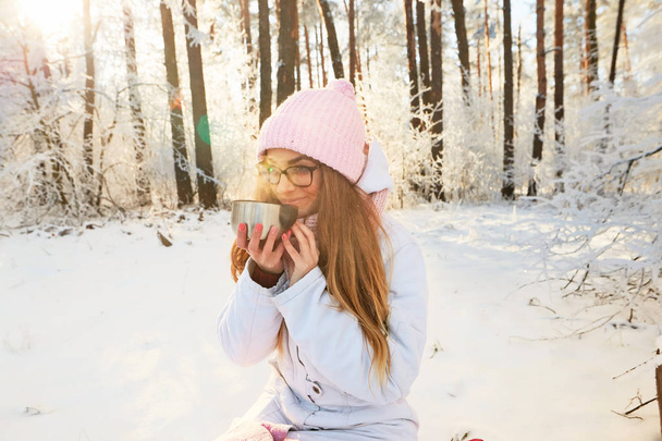 çay bir termos içinde belgili tanımlık kış ormanda içme pembe şapkalı kız. - Fotoğraf, Görsel
