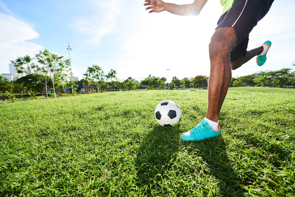 професійний футболіст, що біжить з м'ячем на футбольному полі
 - Фото, зображення