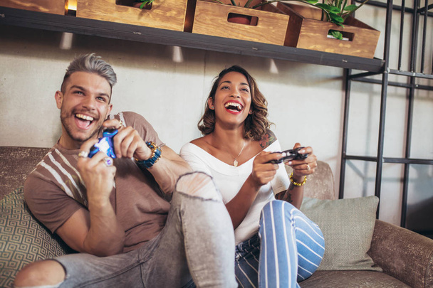 Beautiful couple having fun while playing video games. - Фото, зображення